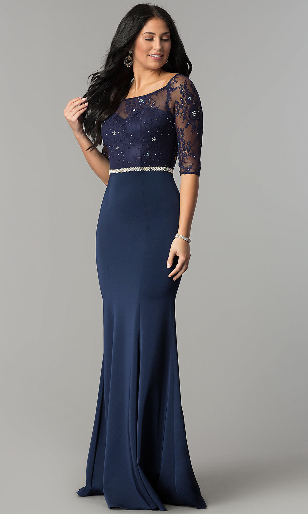 A woman models the Three-Quarter-Sleeve Lace-Bodice Long Prom Dress, featuring a floor-length navy blue skirt and sheer lace bodice with three-quarter sleeves, posed against a plain gray background.